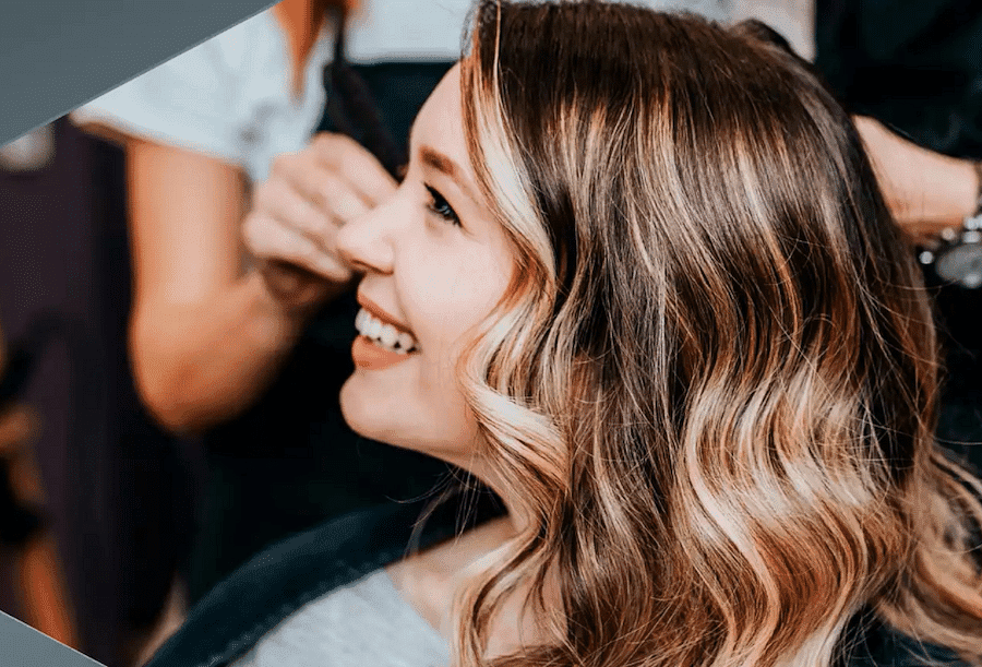 Woman smiling in a salon with her hair styled.